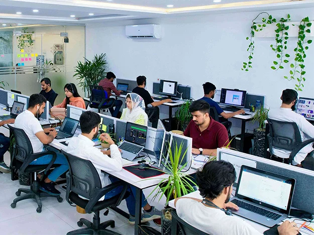 A team of custom software developers working in the edreams ukoffice building in Lahore, Pakistan. The developers are working on a custom software development project, using various tools and technologies to create a high-quality software solution. The image is relevant to the keywords "about us," "custom software development company office," "web development company," "mobile app development company," "application development company," "IT consulting agency" "IT services company," "IT solutions company," "IT outsourcing company," "quality assurance," "mobile apps," "data analytics," "artificial intelligence," "machine learning," "MVP builder," "dedicated teams," "history of edreams ukmission," and "edreams ukoffice building."